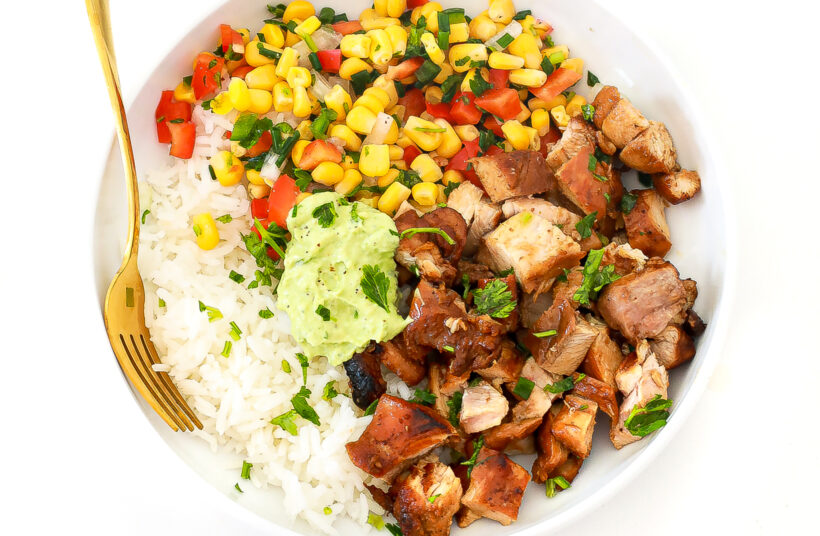 Honey chipotle chicken rice bowl in a white bowl with a gold fork. 