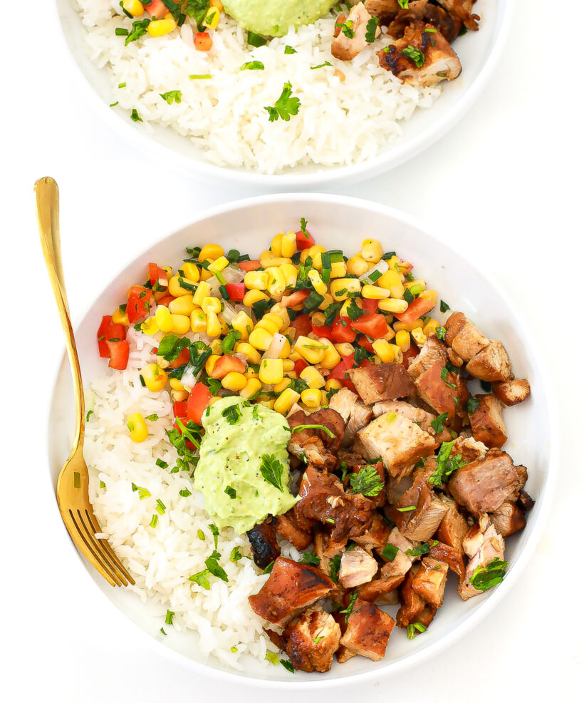 Two honey chipotle chicken rice bowls served in white plates. 