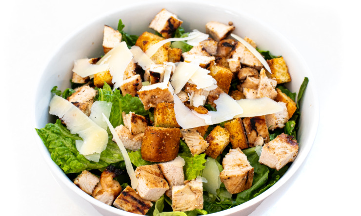 Caesar salad in a white bowl.