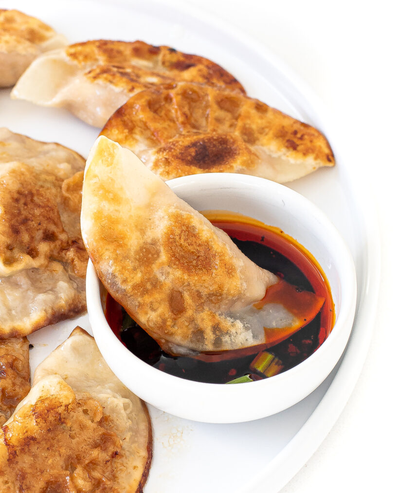 dipping pan fried dumpling in sauce