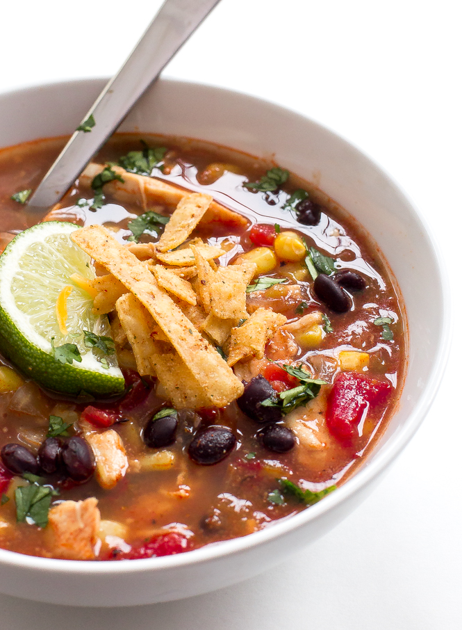 Slow Cooker Chicken Enchilada Soup in white bowl with spoon