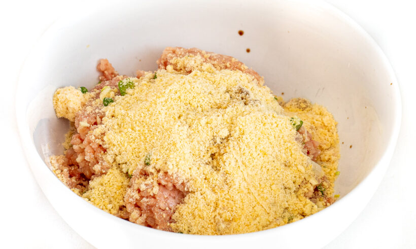 Ingredients for blue cheese meatballs in a white mixing bowl.