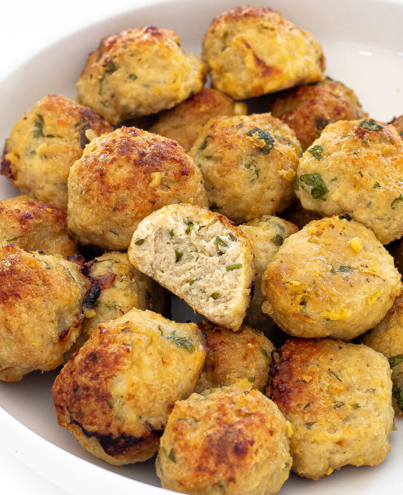 Up close shot of chicken meatballs with one missing a bite. 