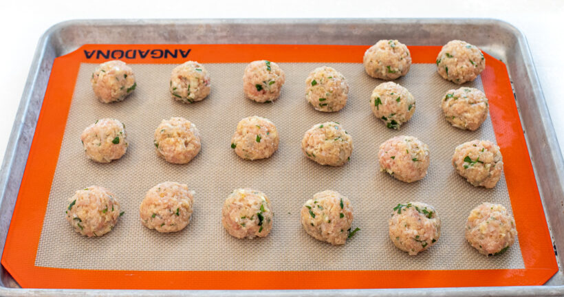 uncooked meatballs on baking sheet