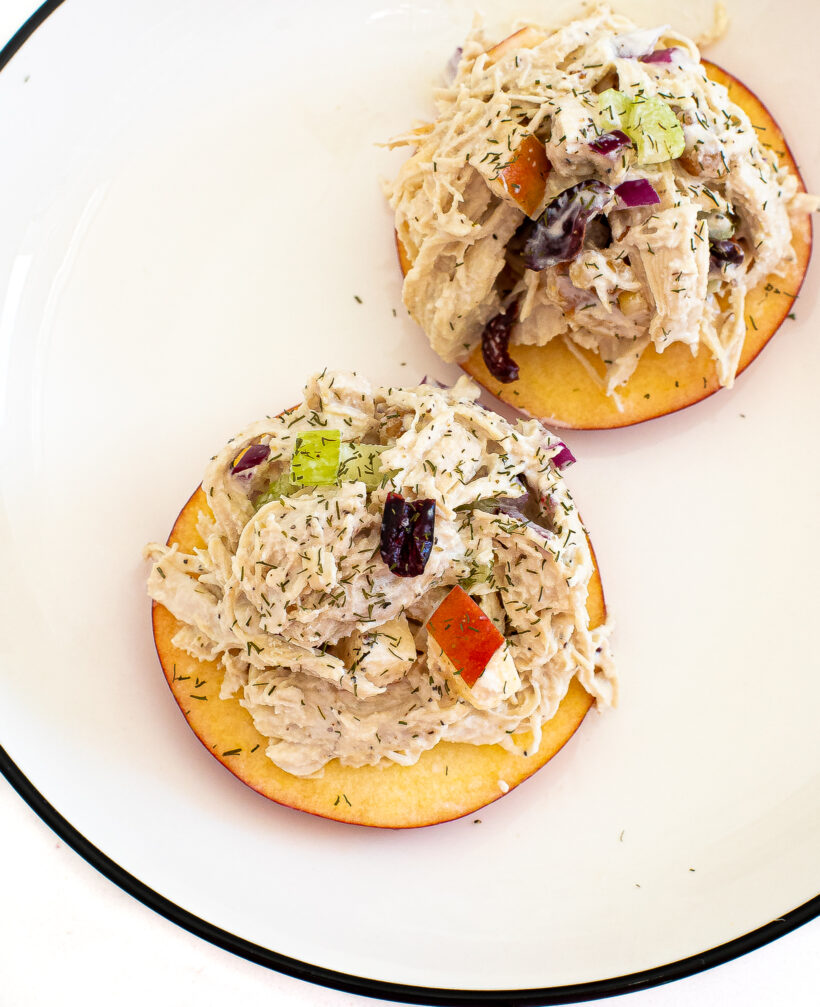 A top down view of harvest chicken salad piled on top of apple slices.