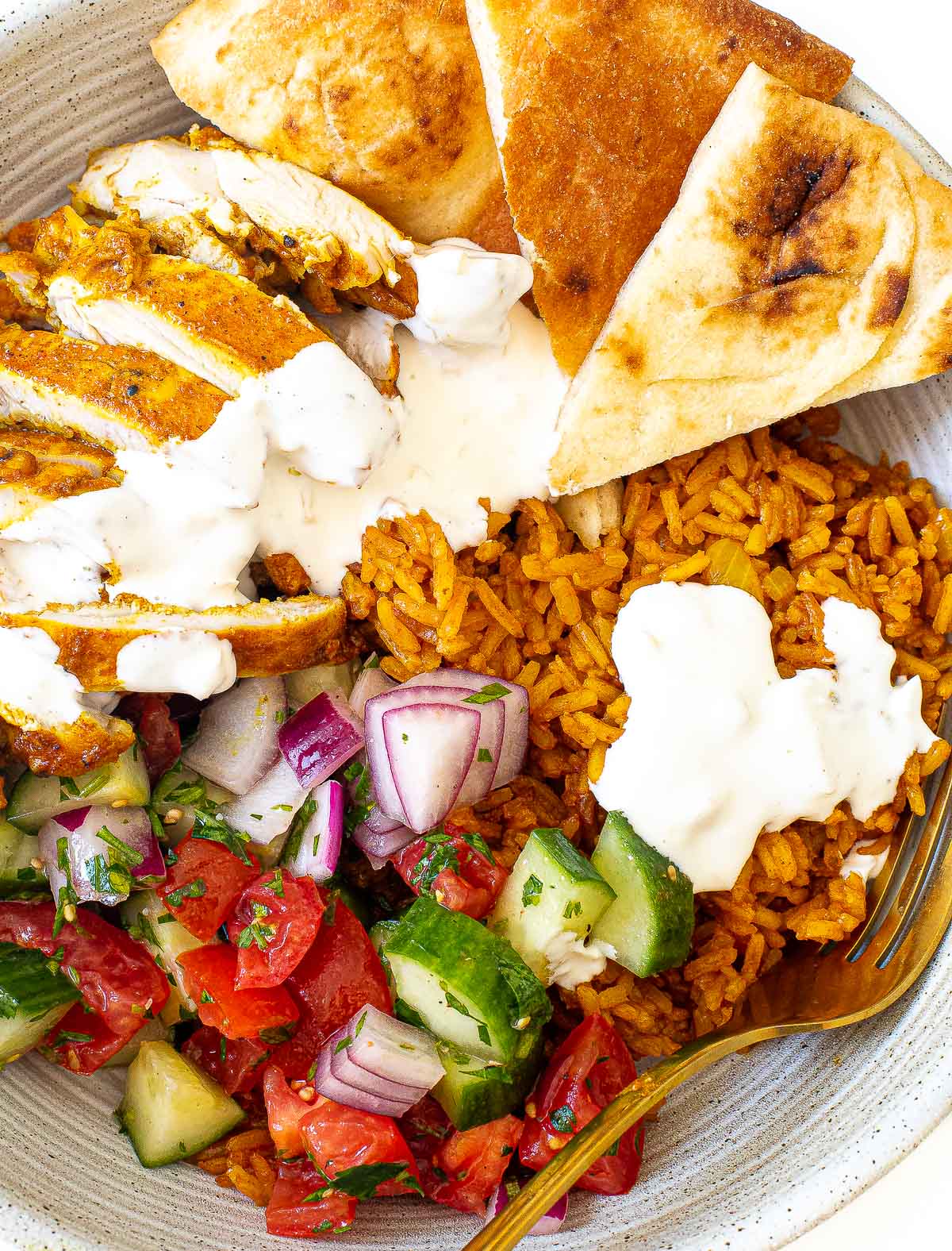 Chicken shawarma bowl drizzled with a white creamy garlic sauce.