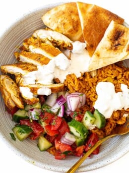 Chicken shawarma bowl with veggies, rice, chicken and naan.