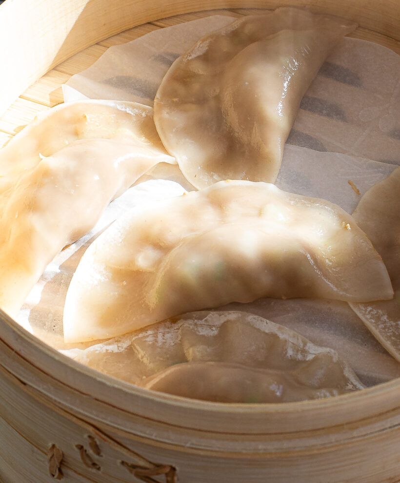 steaming Chinese dumplings in bamboo steamer