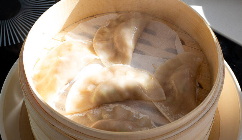 steaming Chinese dumplings in bamboo steamer