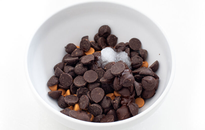 Chocolate chips and butterscotch chips and coconut oil in a small bowl. 