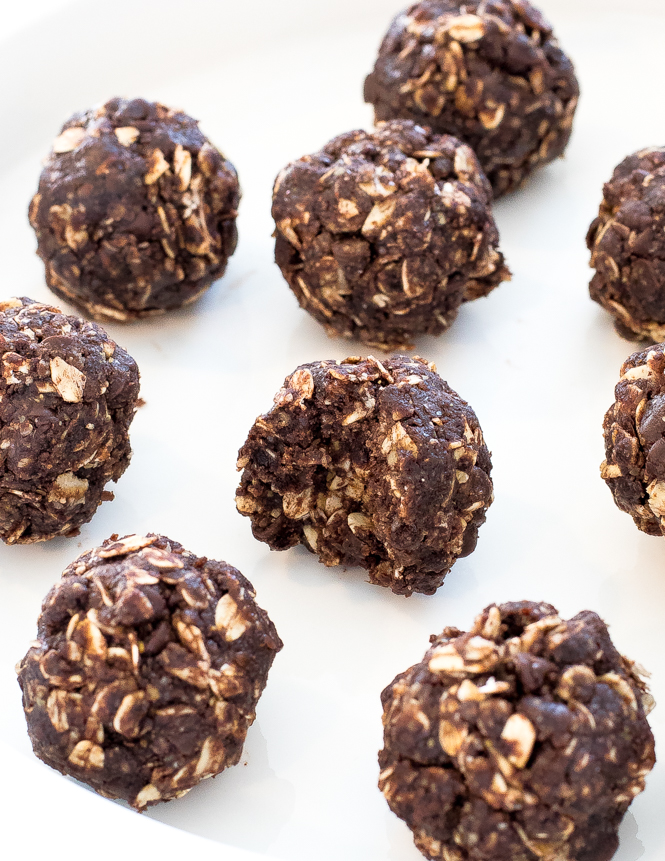 chocolate peanut butter energy bites with a bite taken out of it on white plate