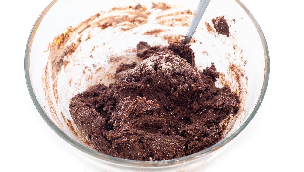 mixing cake mix batter for cookies in a large clear bowl