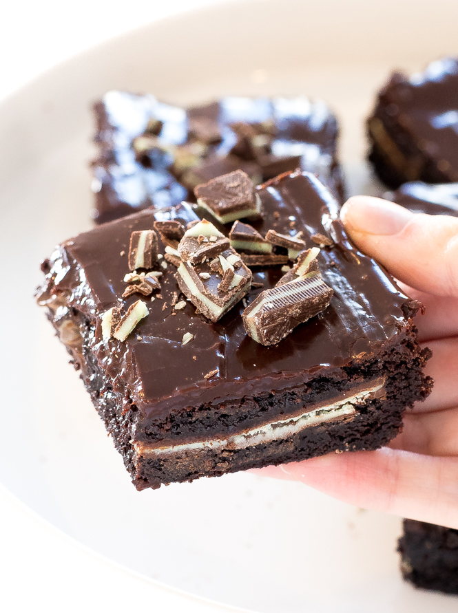 Author holding Chocolate Mint Andes brownies on white serving tray