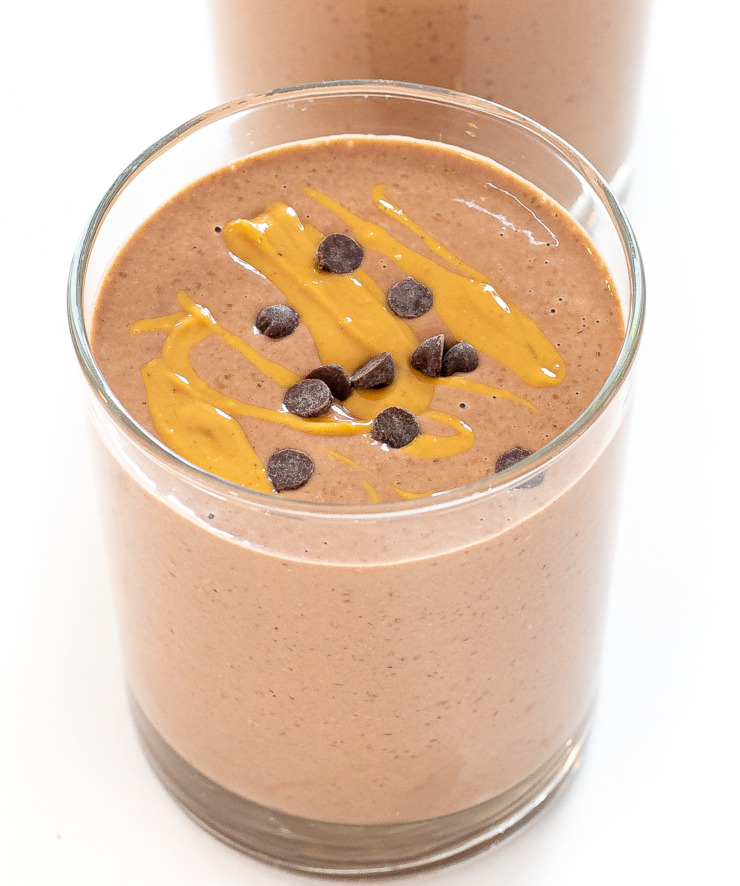 smoothie in glass topped with peanut butter drizzle and mini chocolate chips