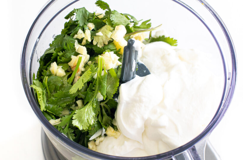 Ingredients for cilantro yogurt sauce in a food processor before being blended. 