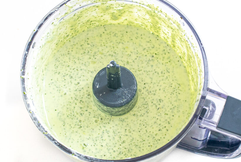 Cilantro yogurt sauce in a food processor after being blended. 