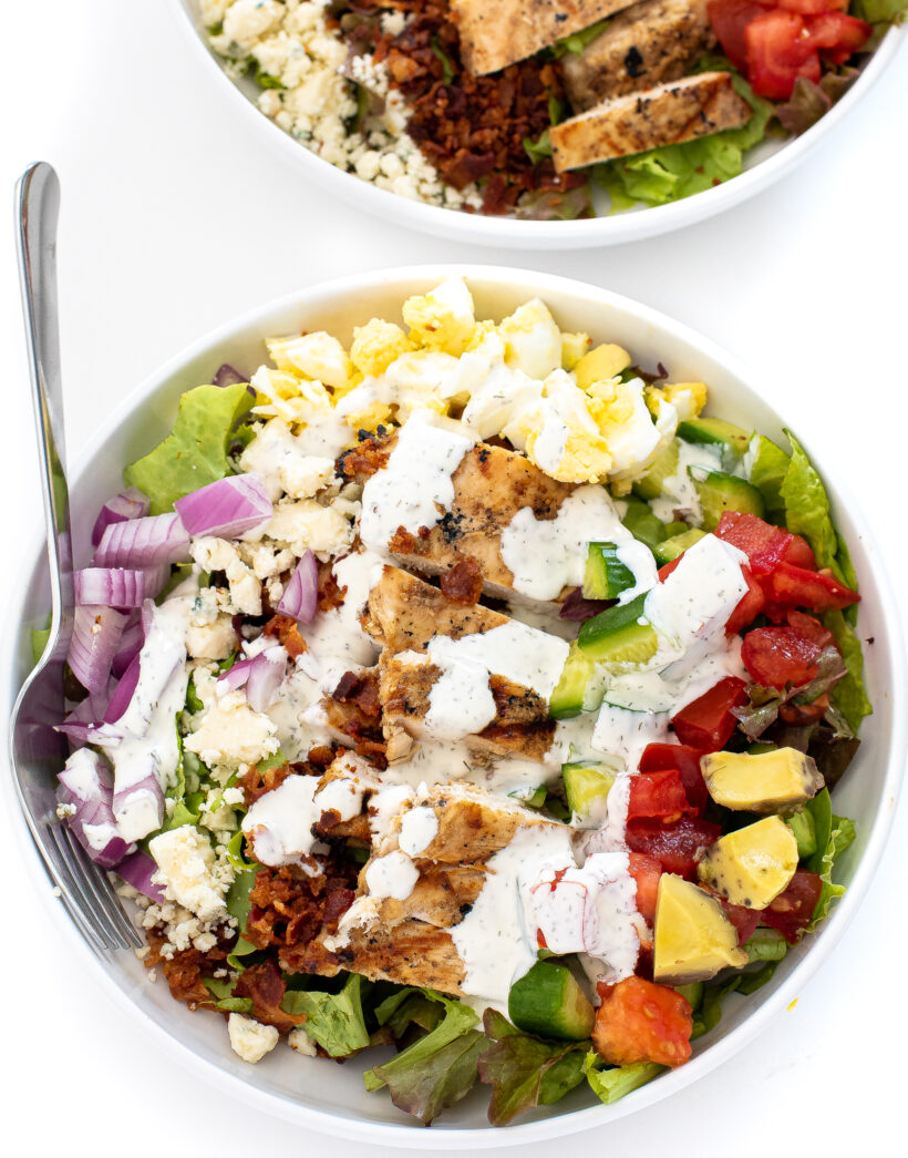 Overhead shot of chicken cobb salad with homemade ranch in a bowl. 