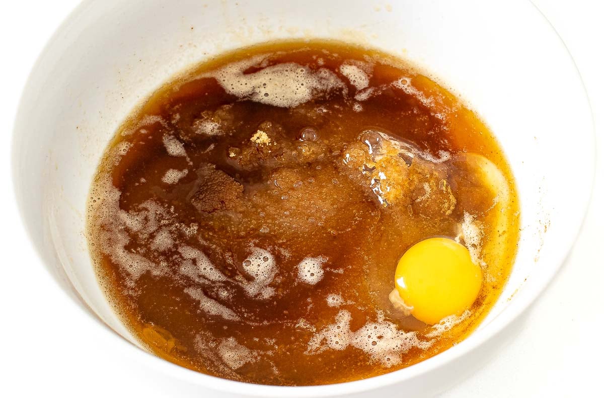 adding wet ingredients to white bowl