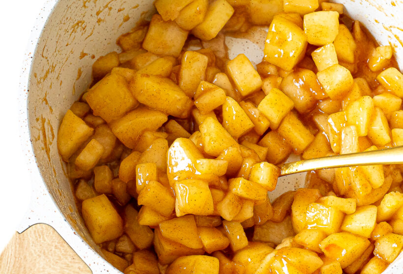 Apple filling in a white saucepan.