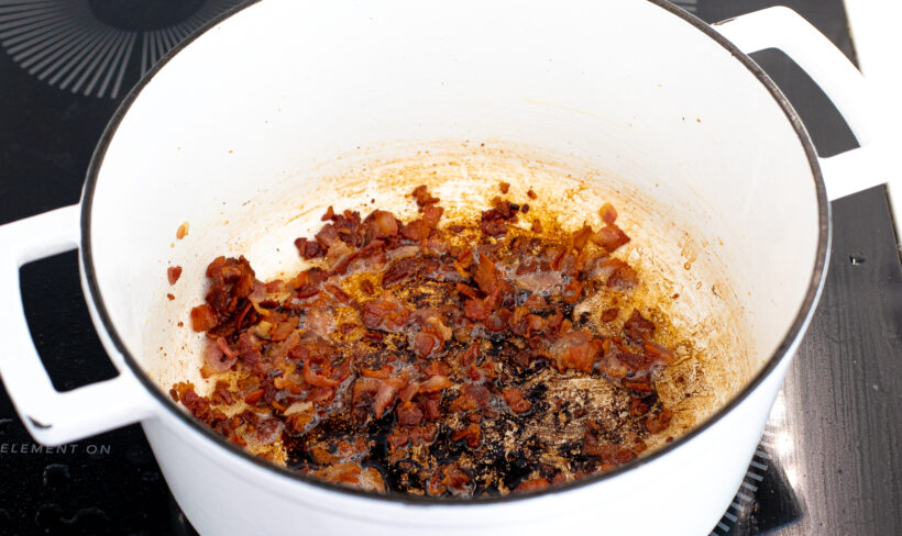 Bacon sautéing in a large dutch oven.