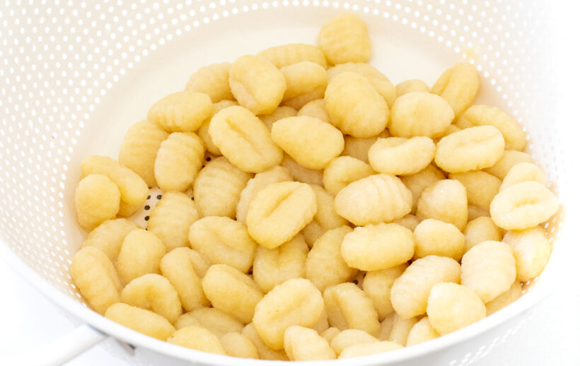 Cooked gnocchi in a colander.