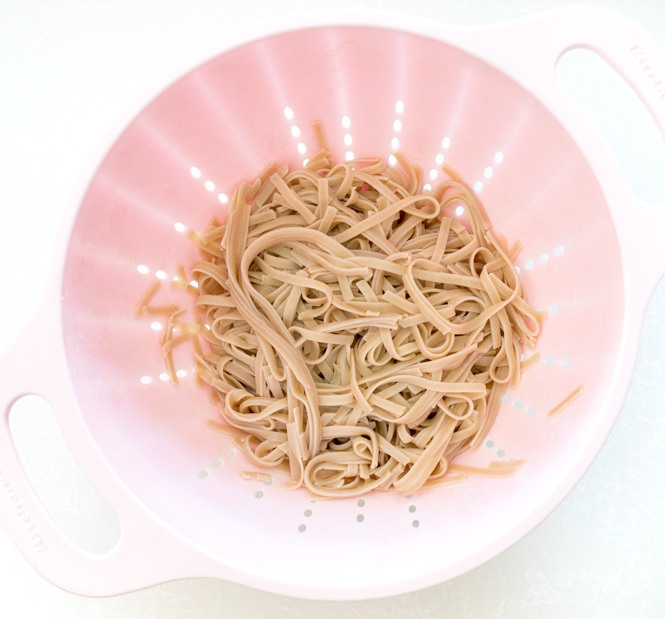 rice noodles in pink colander.