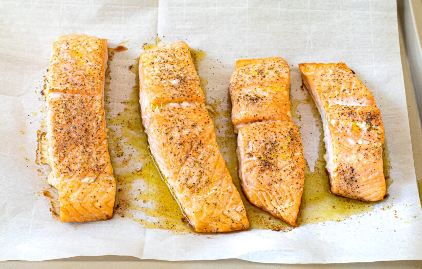 Cooked salmon on a baking sheet lined with parchment paper. 
