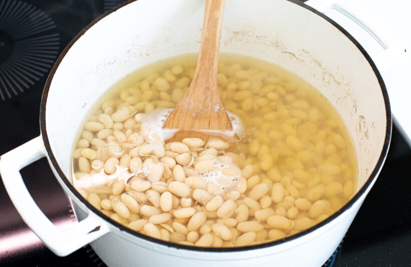 Beans simmering in water on the stove.