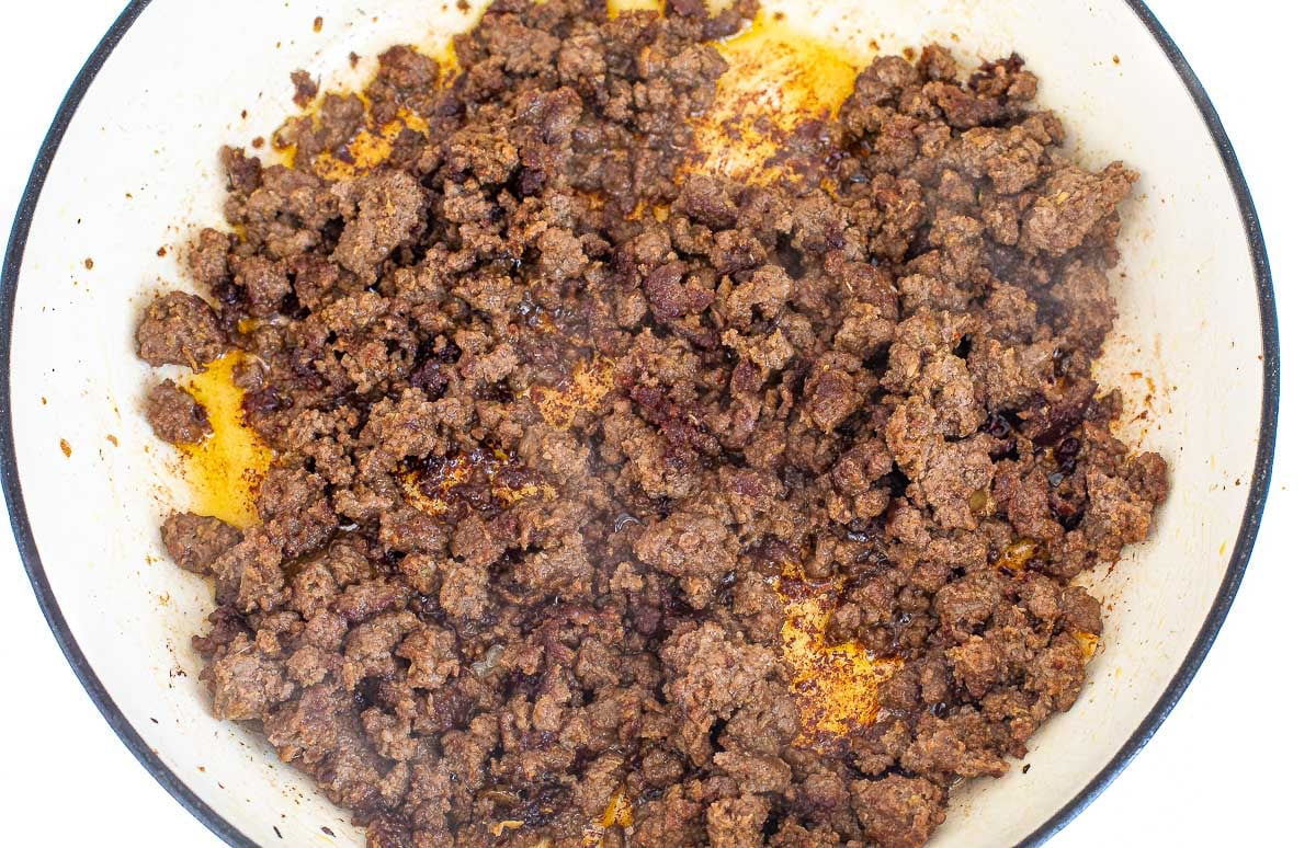 stir frying ground beef in large white pan