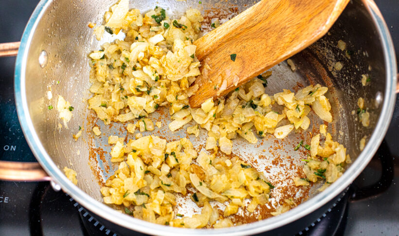 Onions sauteeing in a frying pan.
