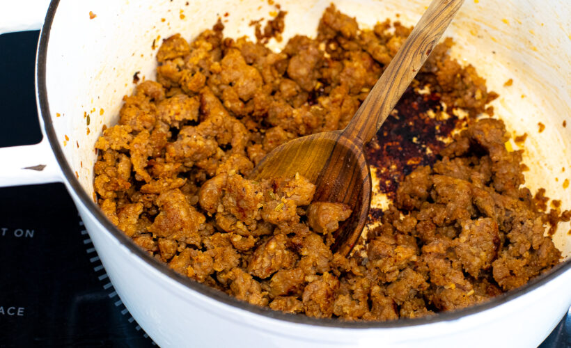 Italian sausage being cooked in the same dutch oven. 
