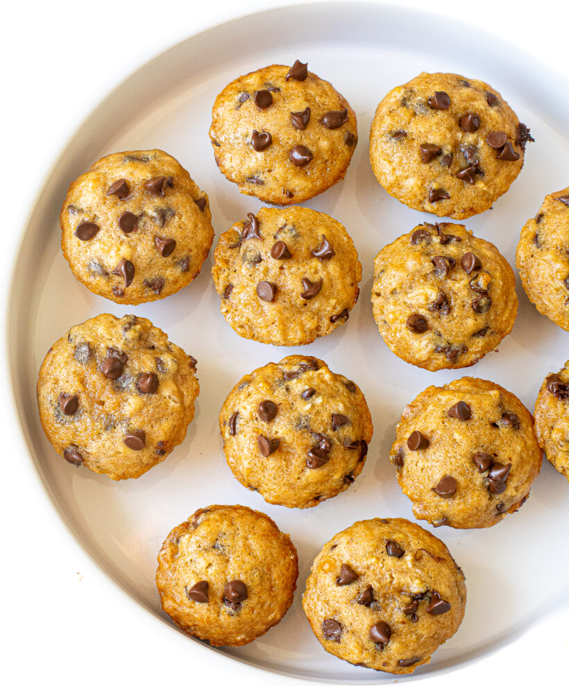 Mini chocolate chip muffins on a white plate.