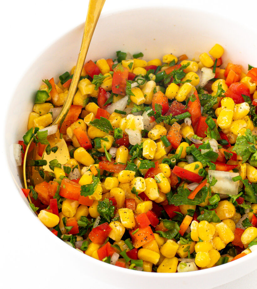 Corn salsa in a bowl with pepper on top. 