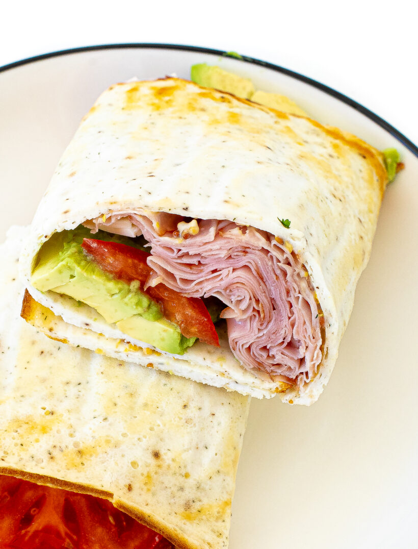 Close up view of a cottage cheese flatbread cut in half to see the fillings inside.