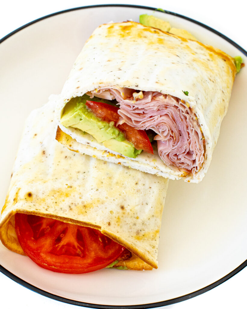 Close up view of a cottage cheese flatbread cut in half to see the fillings inside.