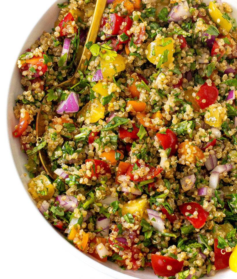 Quinoa tabbouleh salad after it is mixed and served in a white serving bowl.