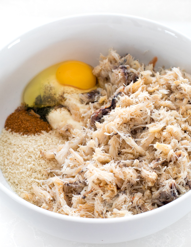 top shot of shredded white meat and other ingredients in white bowl