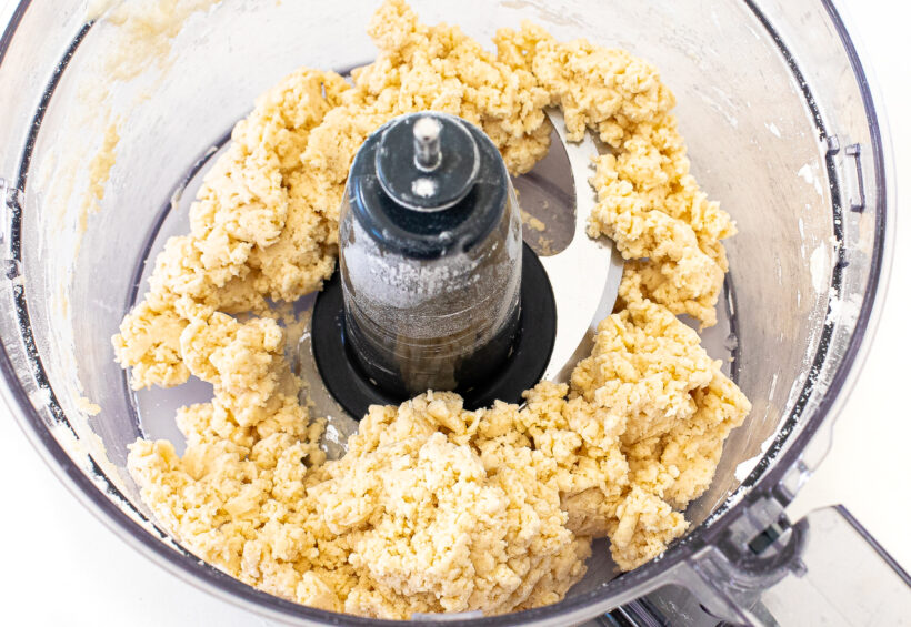 Top down view of a food processor bowl with cracker dough.