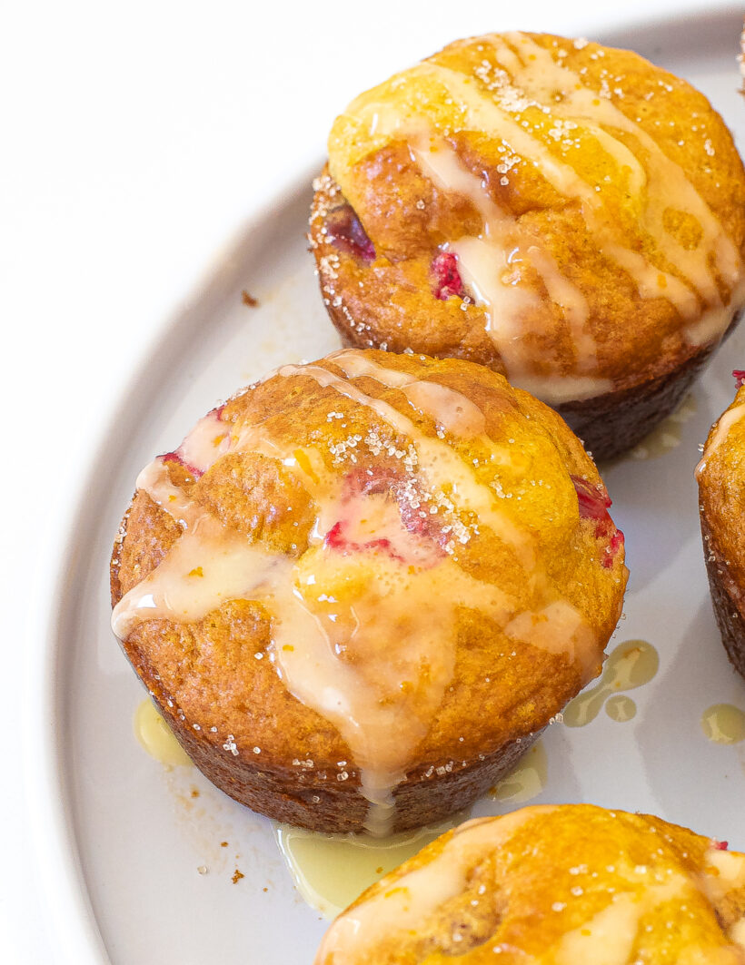 Raspberry Orange Muffins with orange glaze on a white plate.