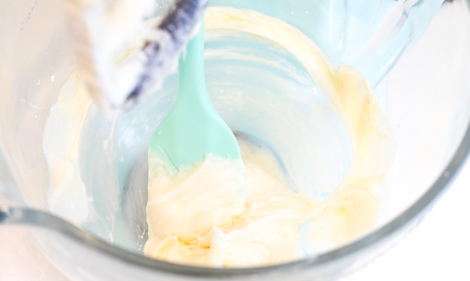 mixing cream cheese frosting in a mixer