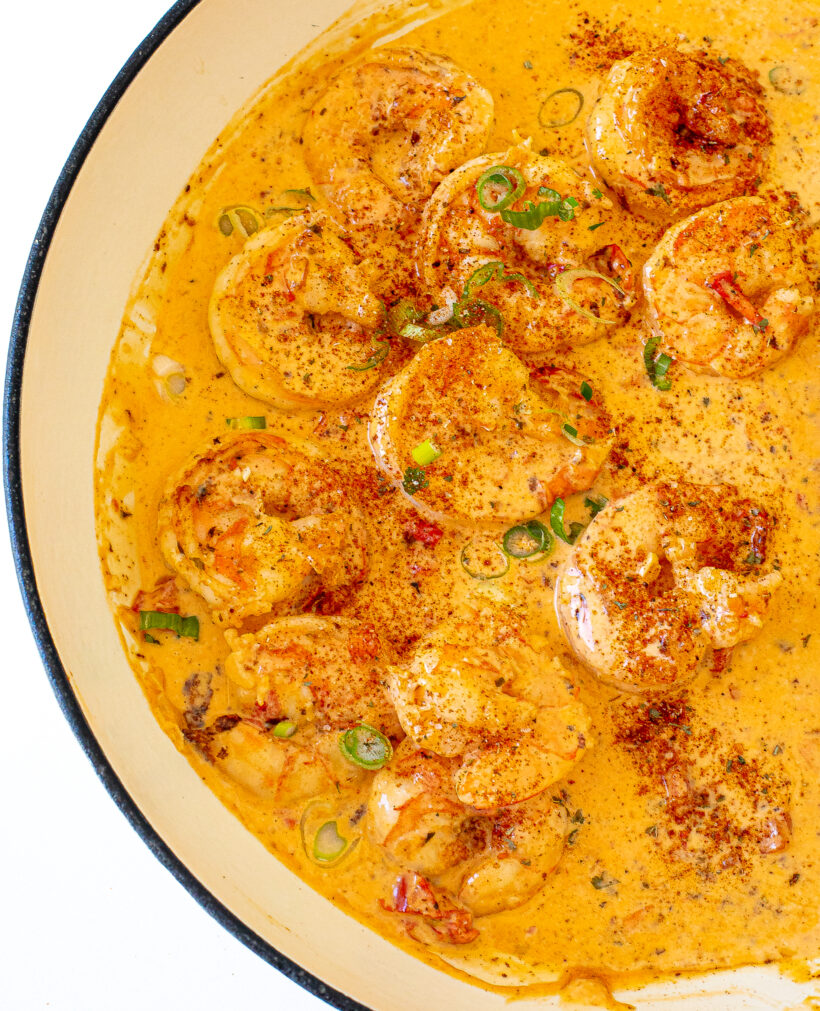 Shrimp coated in cajun sauced in a frying pan.