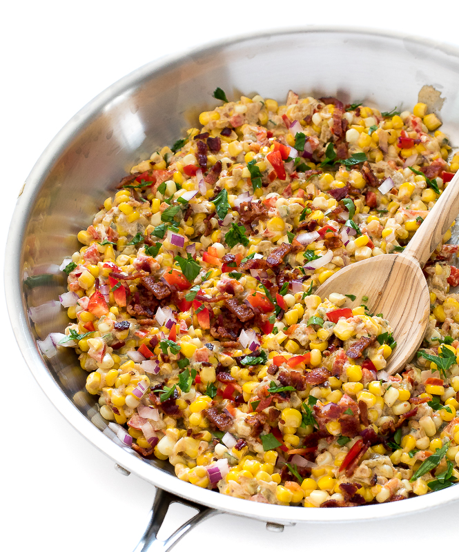 Homemade Confetti Corn with onion, peppers, and bacon in a skillet with a wooden serving spoon | chefsavvy.com