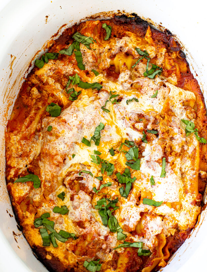 Top down view of slow cooker lasagna in a white crockpot liner.