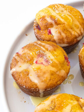 Raspberry Orange Muffins with orange glaze on a white plate.
