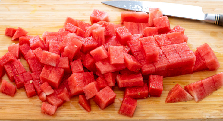 cubed watermelon on wooden cutting board