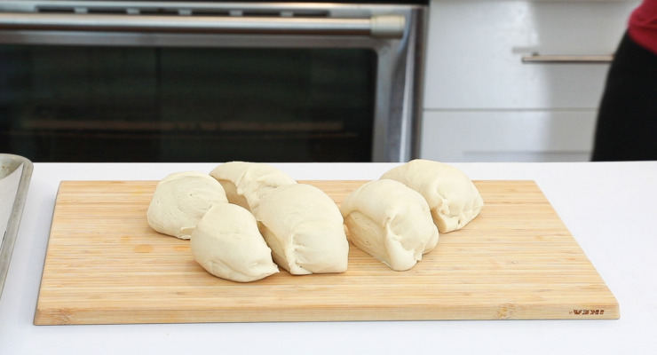 pretzel dough cut into pieces on wooden cutting board