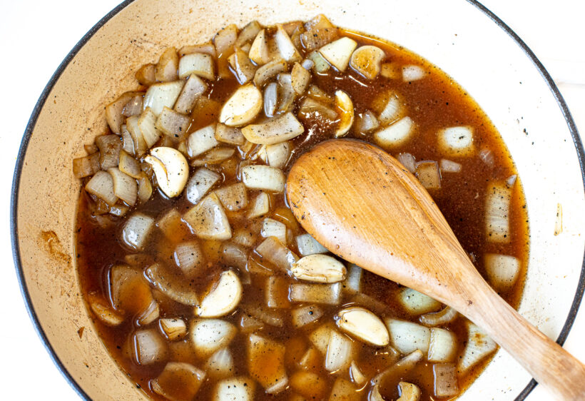 Onions and garlic in broth in a skillet.
