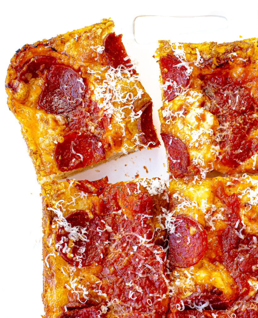 Detroit style pizza with a slice taken out.