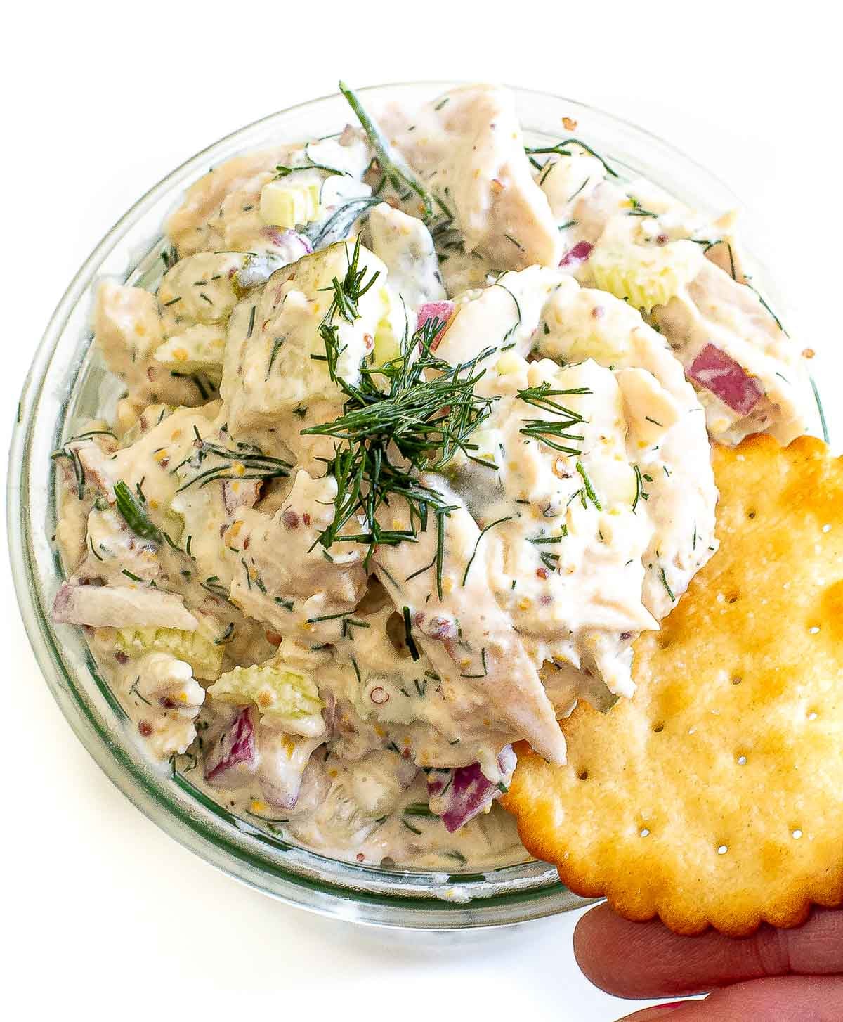 dipping cracker into high protein dill pickle chicken salad