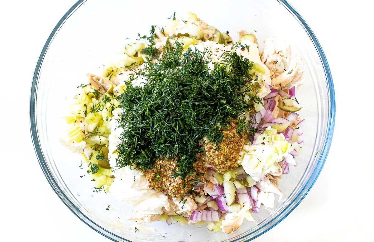 adding fresh dill, mayonnaise and sour cream to a bowl